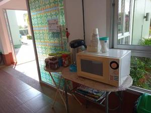 a microwave sitting on a table in a kitchen at 22 Seasons Hotel in Ban Khlong Chi Lat
