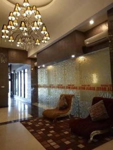 eine Lobby mit 2 Stühlen und einem Kronleuchter in der Unterkunft Radja Hotel in Samarinda