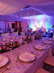 a long table with plates and flowers in a marquee at Filipiniana Hotel Calapan in Calapan
