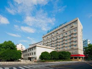 a large building with a hotel on top of it at Magnotel Ningbo Tianyi Plaza Railway Station in Ningbo