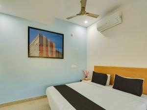 1 dormitorio con 2 camas y TV en la pared en Super Collection O QUALIA PRIME HOTEL NEAR NEXUS MALL, en Hyderabad