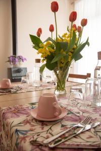 un tavolo con un vaso di fiori e un vaso di fiori di Dimora cAmelia a Lucera