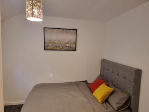 een slaapkamer met een bed en een foto aan de muur bij Rehoboth Living in Thamesmead