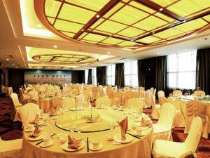 a large banquet hall with white tables and white chairs at Zibo Blue Horizon International Hotel in Zibo
