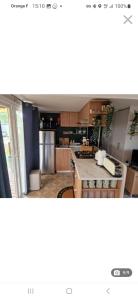 uma cozinha com armários de madeira e uma bancada em Mobil home tout confort au Camping Les Viviers, Cap Ferret em Claouey