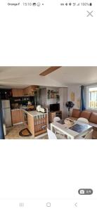 a kitchen and a living room with a table at Mobil home tout confort au Camping Les Viviers, Cap Ferret in Claouey