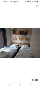 Habitación con 2 camas y 2 lámparas en la pared. en Mobil home tout confort au Camping Les Viviers, Cap Ferret en Claouey