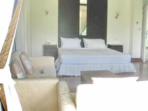 a hotel room with two beds and a couch at Kasem Garden Hotel Surin in Ban Nong Tao