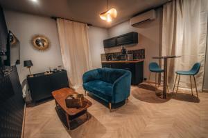 sala de estar con silla azul y mesa en Love Room L'Aixtase - Oasis Romantique à Aix-les-Bains en Aix-les-Bains