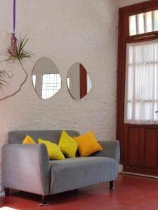 a couch with yellow pillows in a room with mirrors at ALPATACAL in Rosario