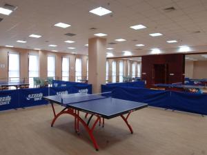 ShuangliuにあるSichuan Tennis International Hotel Main Buildingの青いパーティションの客室内の卓球台