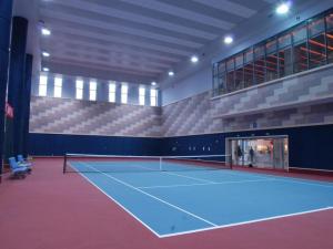 ShuangliuにあるSichuan Tennis International Hotel Main Buildingのテニスラケット付きの建物内のテニスコート
