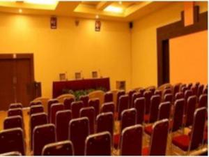 Abadi Hotel Sarolangun by Tritama Hospitality في Sarolangun: قاعة افراغ فيها كراسي ومنضدة في غرفة