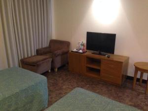 een woonkamer met een televisie en een stoel bij Bayfront Hotel Subic in Olongapo