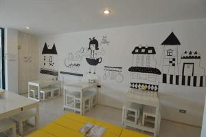 una habitación con mesas y una pared con dibujos. en U Style Hotel en Ban Phang Khwang Tai