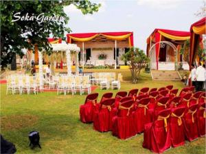 un set para una boda con sillas rojas y blancas en Amalia Hotel Lampung, en Lampung