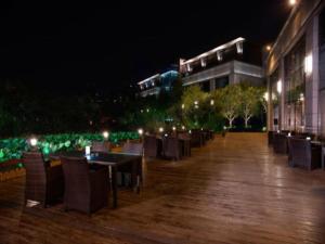 a row of tables and chairs on a patio at night at Changzhou Fudu Qingfeng Garden Hotel in Beigang