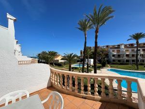 a balcony with a pool and palm trees at Denia Blau-Serviden in Denia
