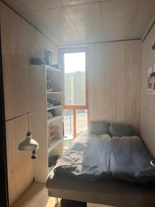 - une petite chambre avec un lit et une fenêtre dans l'établissement Smuk arkitekttegnet hus i Newyorker-stil, à Copenhague