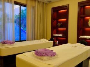 two beds in a room with purple plates on them at Changsha ST-Tropez Hotel in Xingsha