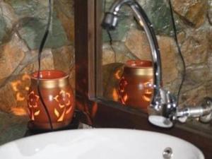 uma casa de banho com duas velas ao lado de um lavatório em Villa Isabel Hotel em Sorsogon