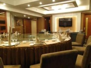 Cette grande chambre comprend une grande table et des chaises. dans l'établissement Zhoushan Changzheng Spring Hotel, à Liangmaotou