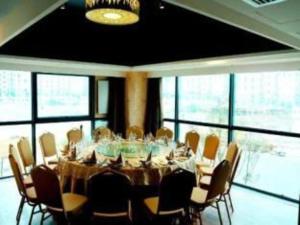 une grande salle à manger avec une table et des chaises dans l'établissement Zhoushan Changzheng Spring Hotel, à Liangmaotou