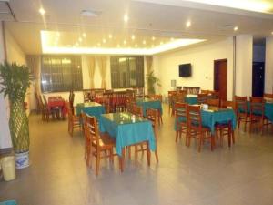 une salle à manger avec des tables bleues et des chaises en bois dans l'établissement GreenTree Inn Jiangsu Wuxi Meiyuan Kaiyuan Temple Subway Master Station Express Hotel, à Xuedian