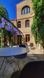 Capsula hotel في يريفان: طاولة أمام مبنى به زهور أرجوانية