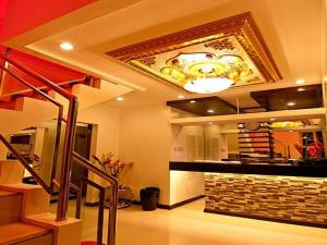 Asog County Hotel في Iriga City: غرفة معيشة بها موقد وسقف