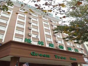 a green tree inn sign in front of a building at GreenTree Inn Bozhou Weiwu Road Hotel in Bozhou