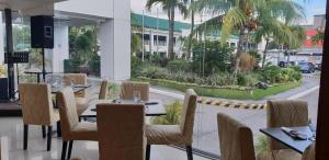un restaurante con mesas y sillas y vistas a la calle en East Asia Royale Hotel en Lagao