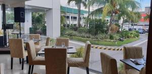 a restaurant with tables and chairs and a view of a street at East Asia Royale Hotel in General Santos