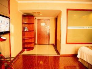 a room with a hallway with a bed and a door at GreenTree Inn Bozhou Weiwu Road Hotel in Bozhou