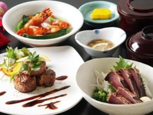 una mesa con platos de comida y tazones de comida en Hotel SP Haruno, en Mimase