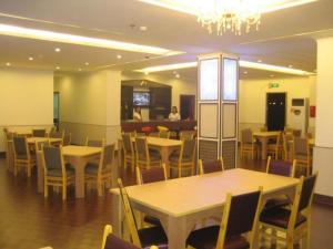 uma sala de jantar com mesas e cadeiras e uma pessoa em Grand Hoyah Hotel em Olongapo