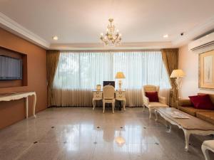 a living room with a couch and a table at Romance Hotel Srinakarin in Bangna