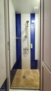 La salle de bains est pourvue d'une douche avec du carrelage bleu et blanc. dans l'établissement Capsula hotel, à Erevan