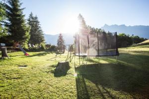 a batting cage in a field with the sun shining at Aktiv-Ferienwohnungen Pienz-Bobnar in Sautens +140 photos