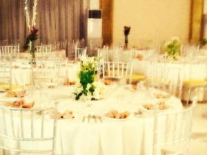 ein Zimmer mit weißen Tischen, weißen Stühlen und Blumen in der Unterkunft Regal Plaza Hotel in Nabua