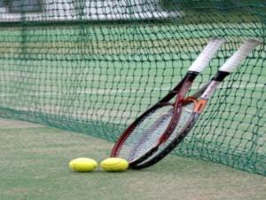 two tennis rackets and two tennis balls on a court at Izu Inatori Sports Villa in Higashiizu