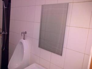 urinol branco numa casa de banho com espelho em @thome em Sukodono