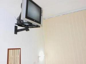 uma televisão de ecrã plano no canto de uma parede em @thome em Sukodono