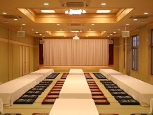 a conference room with rows of chairs and a stage at Nanaironoyu Hotel in Takeo