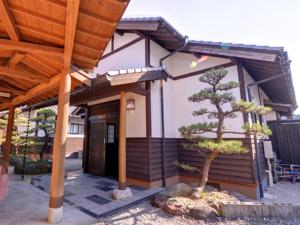 a small house with a tree in front of it at Nanaironoyu Hotel in Takeo