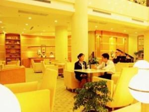 Dois homens sentados à mesa num restaurante em Jincheng Pacific Hotel em Jingcheng