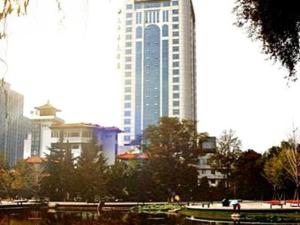 um edifício alto numa cidade com árvores e edifícios em Jincheng Pacific Hotel em Jingcheng