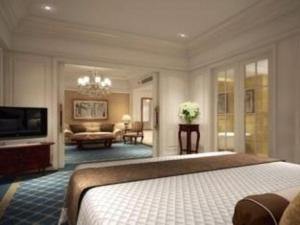 1 dormitorio con 1 cama y sala de estar en Zhengzhou Yiquan International Hotel, en Zhengzhou