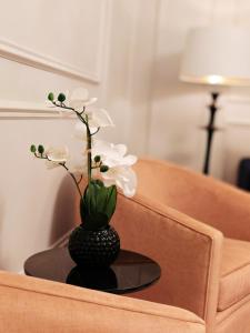 a black vase with white flowers on a table at Frederick House Hotel in Edinburgh