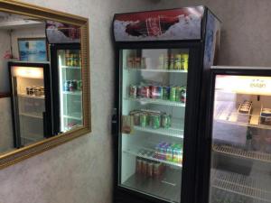 einen Kühlschrank mit offener Tür neben einem Spiegel in der Unterkunft Guam Airport Hotel in Tumon